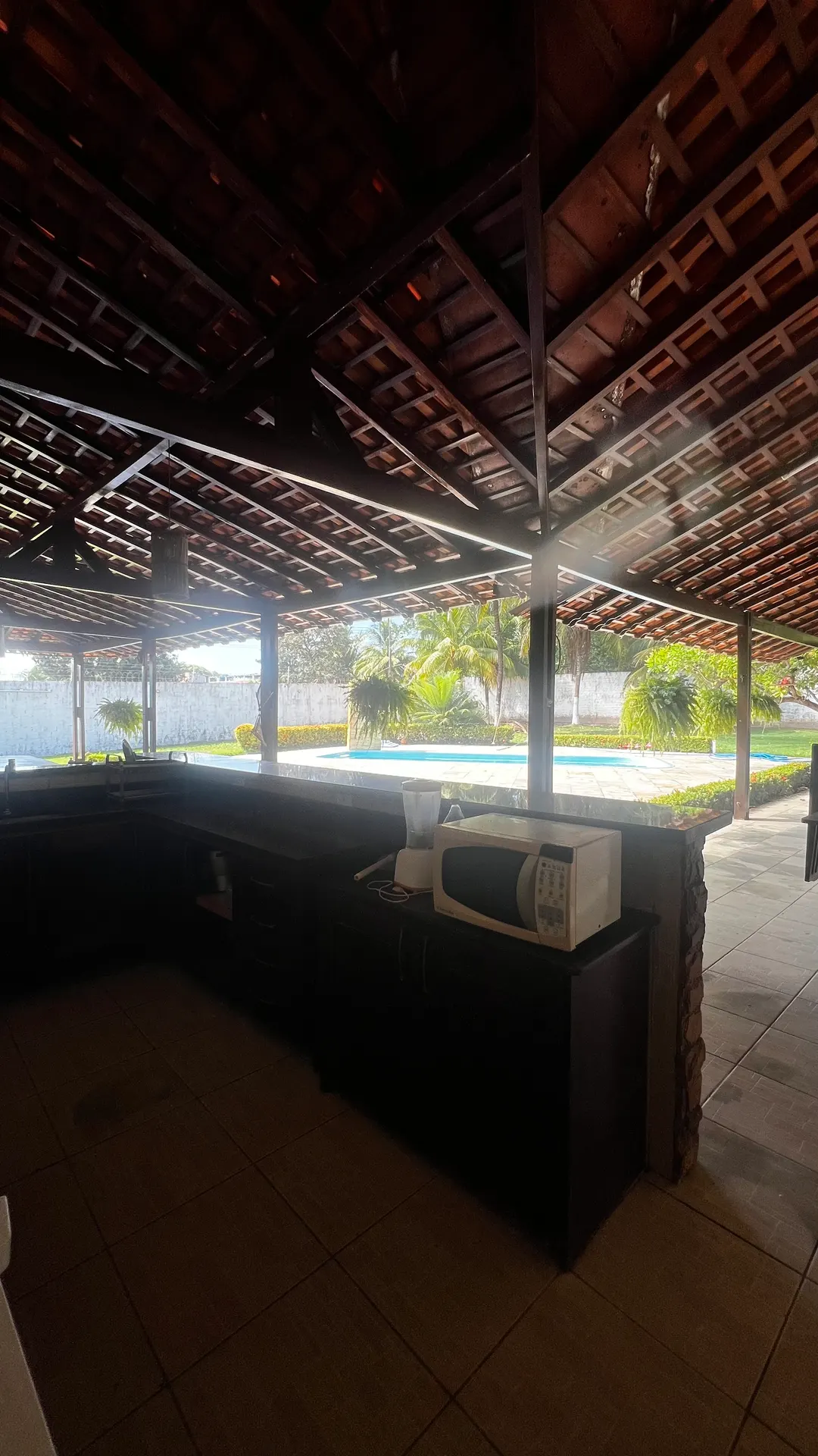 Bancada da área gourmet com vista para a piscina